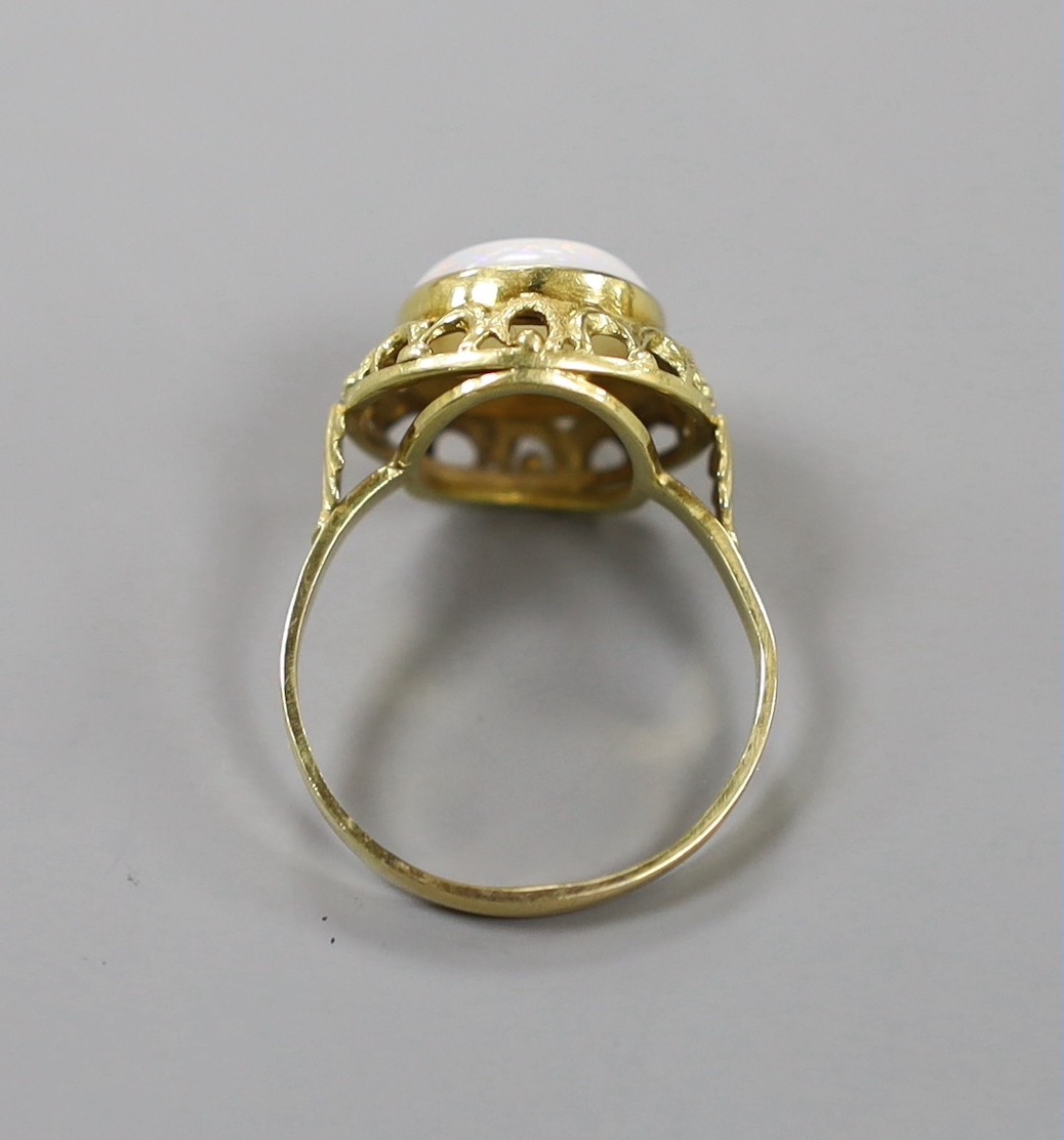 A 750 yellow metal and cabochon white opal set ring, with pierced setting, size U/V, gross weight 5 grams.